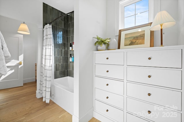 bathroom with shower / bath combo with shower curtain and wood finished floors