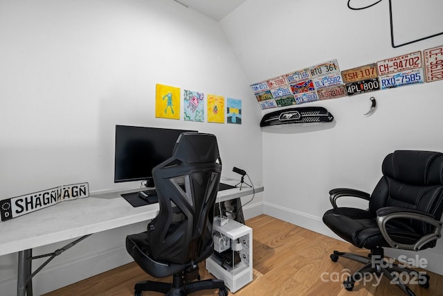 home office featuring lofted ceiling, baseboards, and wood finished floors