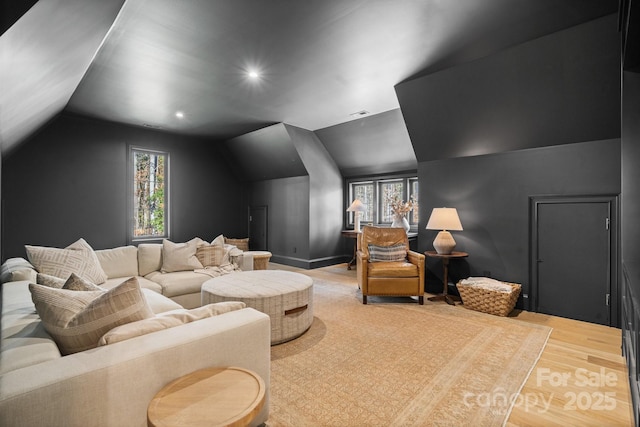 cinema room with lofted ceiling, recessed lighting, visible vents, wood finished floors, and baseboards