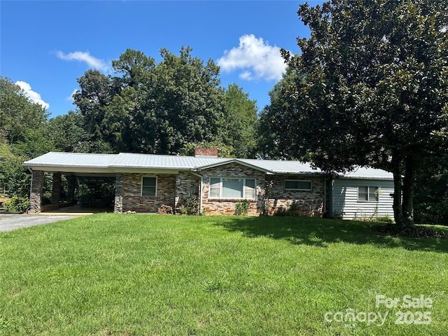 ranch-style home featuring a front lawn and a carport