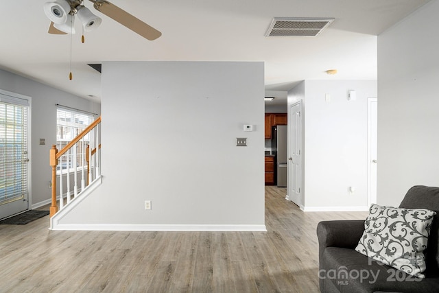 living room featuring ceiling fan and light wood-type flooring