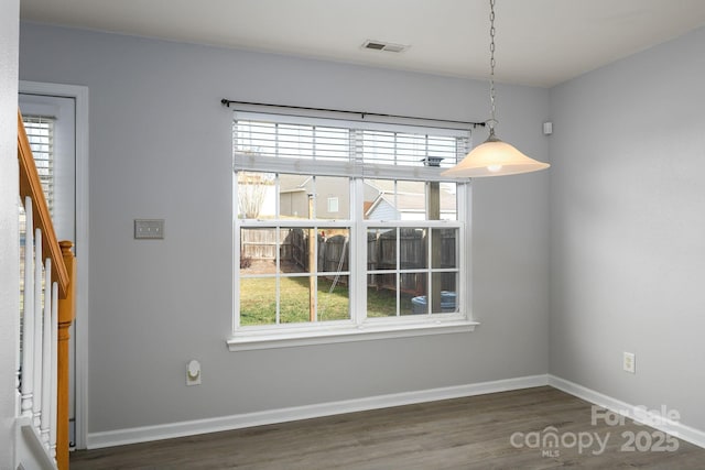 unfurnished dining area with dark hardwood / wood-style flooring and plenty of natural light