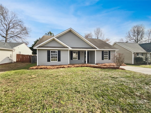 single story home with driveway, fence, and a front lawn