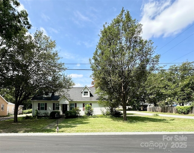 cape cod home featuring a front lawn