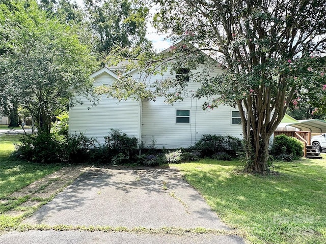 view of side of property featuring a yard and a carport