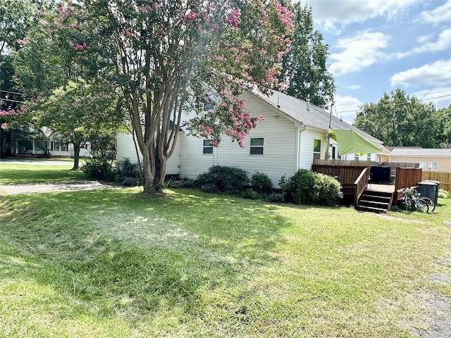 view of side of property with a yard and a wooden deck