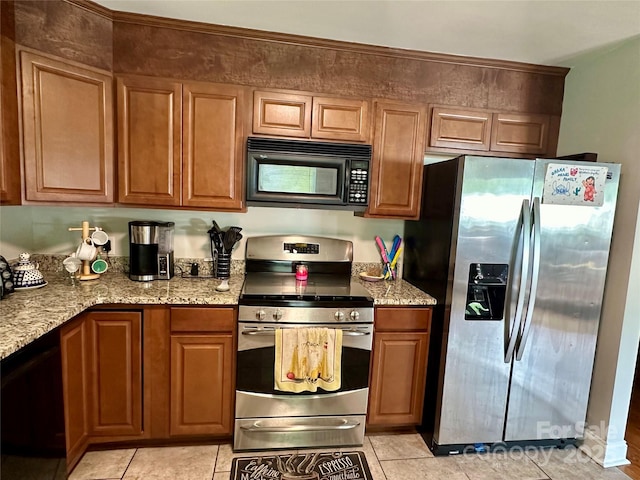 kitchen with light tile patterned flooring, light stone countertops, and black appliances