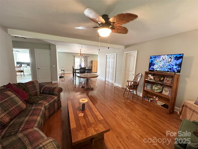 living room with hardwood / wood-style floors and ceiling fan with notable chandelier