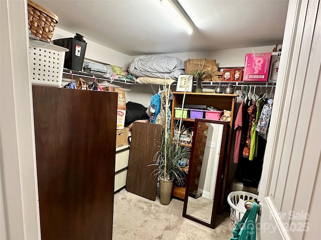 walk in closet featuring light colored carpet