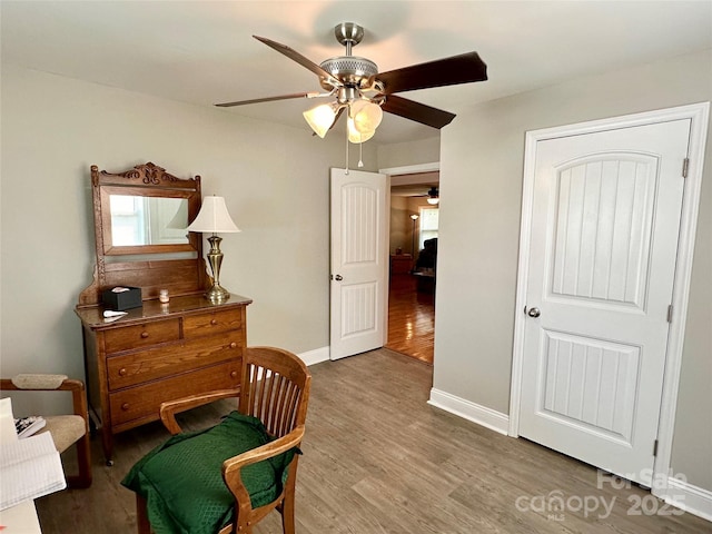 living area with hardwood / wood-style floors and ceiling fan