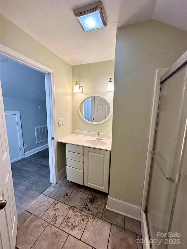 bathroom with lofted ceiling, vanity, and a shower with door