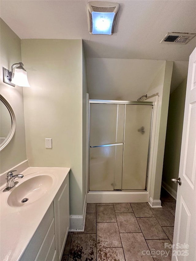 bathroom with tile patterned floors, a shower with door, and vanity