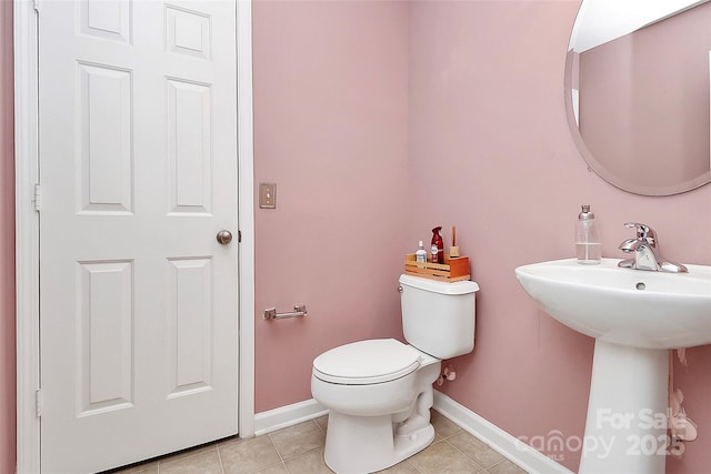 half bathroom featuring baseboards, toilet, and tile patterned floors