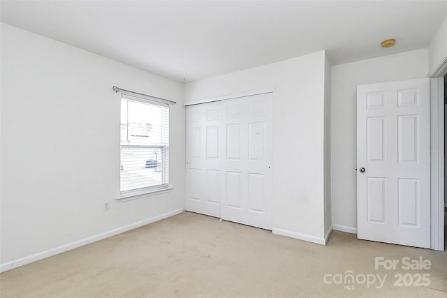 unfurnished bedroom with carpet, baseboards, and a closet