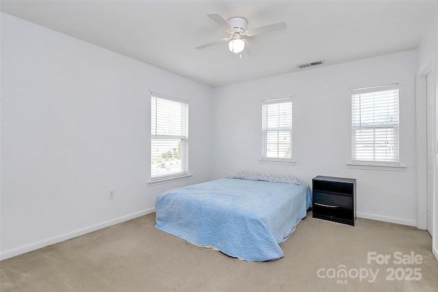 bedroom with light carpet, multiple windows, visible vents, and baseboards