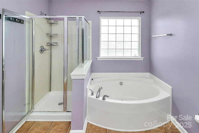 bathroom with a garden tub, a shower stall, and tile patterned flooring