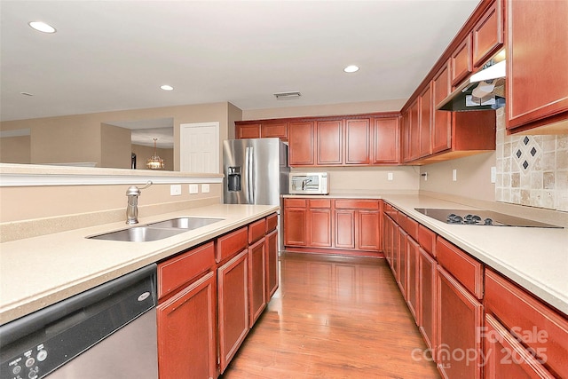 kitchen with visible vents, light wood-style floors, appliances with stainless steel finishes, under cabinet range hood, and a sink