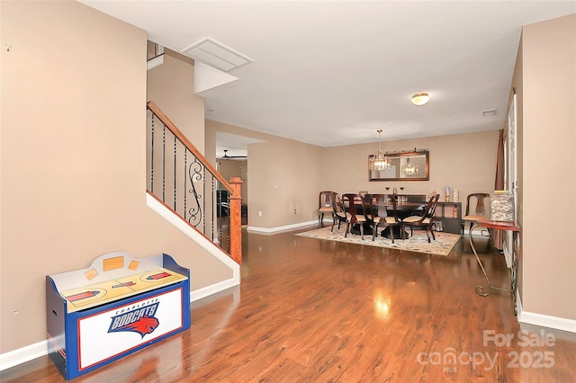 dining room with visible vents, stairway, baseboards, and wood finished floors