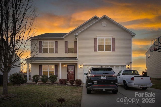 traditional home with a front yard, concrete driveway, and an attached garage