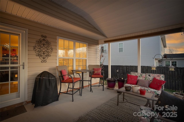 patio terrace at dusk featuring fence