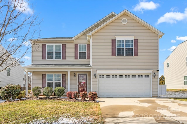 traditional-style house featuring an attached garage, driveway, and a front yard