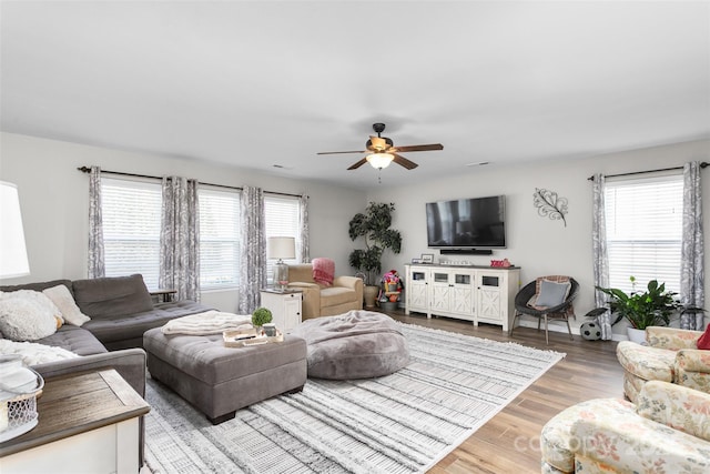 living area with a ceiling fan and wood finished floors