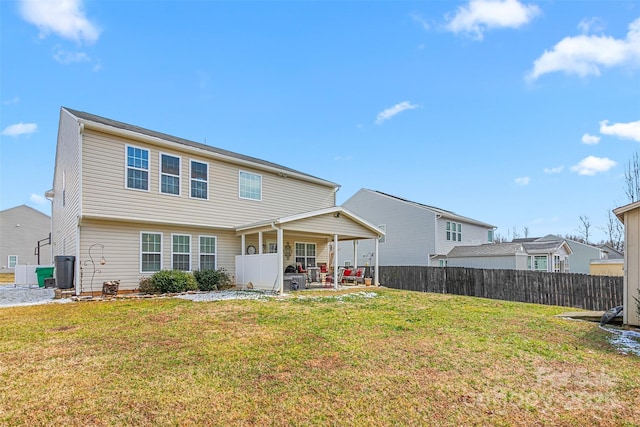 rear view of property featuring a yard, a patio, and fence