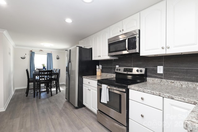 kitchen featuring white cabinetry, appliances with stainless steel finishes, tasteful backsplash, and wood finished floors