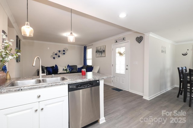 kitchen featuring crown molding, hanging light fixtures, white cabinets, a sink, and dishwasher