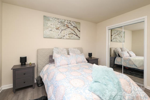 bedroom featuring a closet, wood finished floors, and baseboards