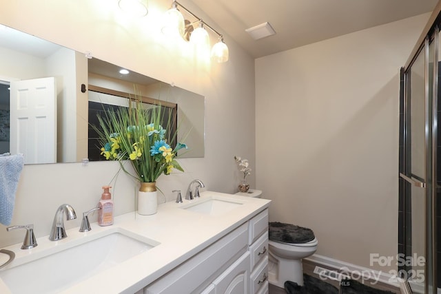 bathroom with a shower with shower door, a sink, toilet, and double vanity