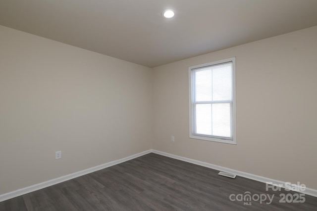 unfurnished room featuring recessed lighting, dark wood finished floors, visible vents, and baseboards