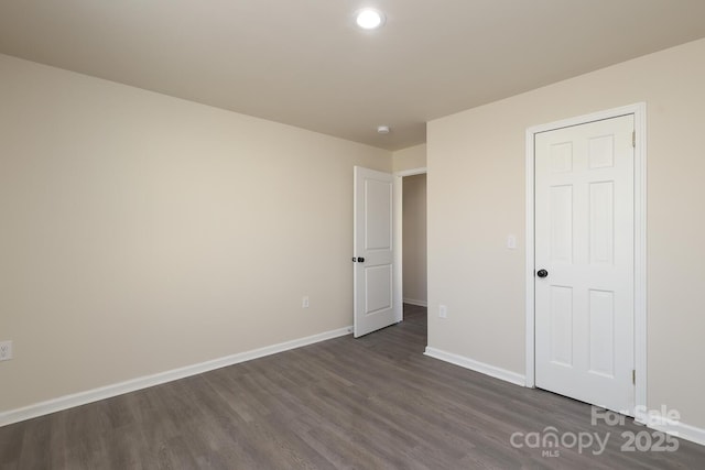 unfurnished bedroom featuring dark wood finished floors and baseboards