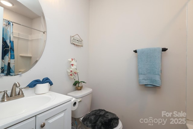 bathroom featuring a shower with shower curtain, vanity, and toilet