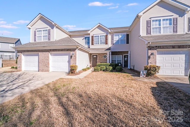 townhome / multi-family property featuring concrete driveway, brick siding, and roof with shingles