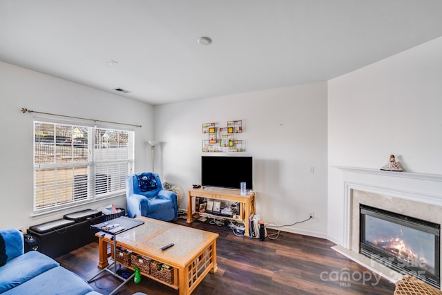 living room featuring a fireplace, dark wood finished floors, and visible vents