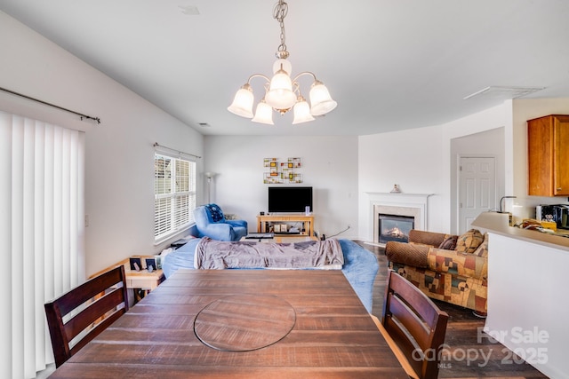 dining area featuring an inviting chandelier and a high end fireplace