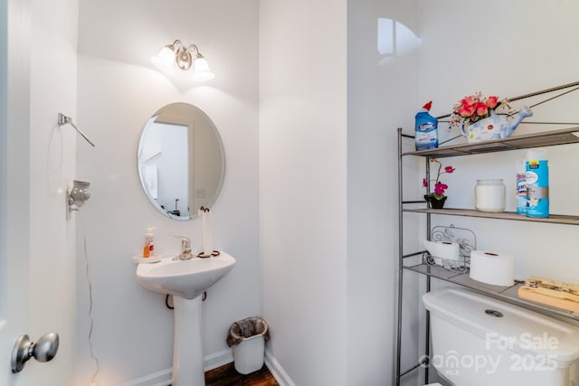 bathroom with baseboards and toilet