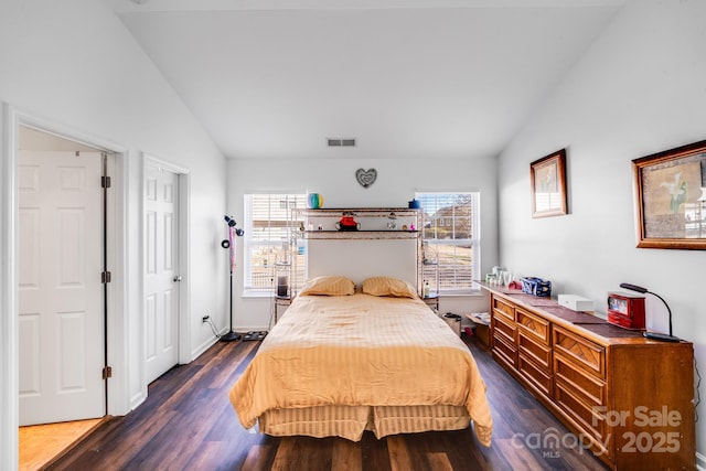 bedroom featuring dark wood-style floors, visible vents, and vaulted ceiling