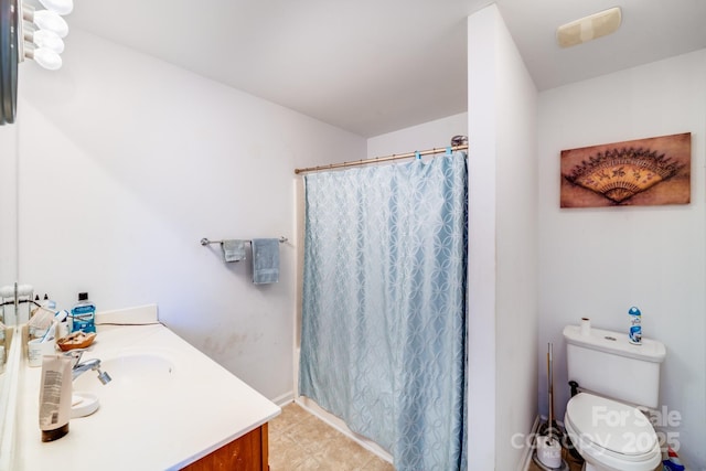 bathroom with curtained shower, vanity, toilet, and tile patterned floors