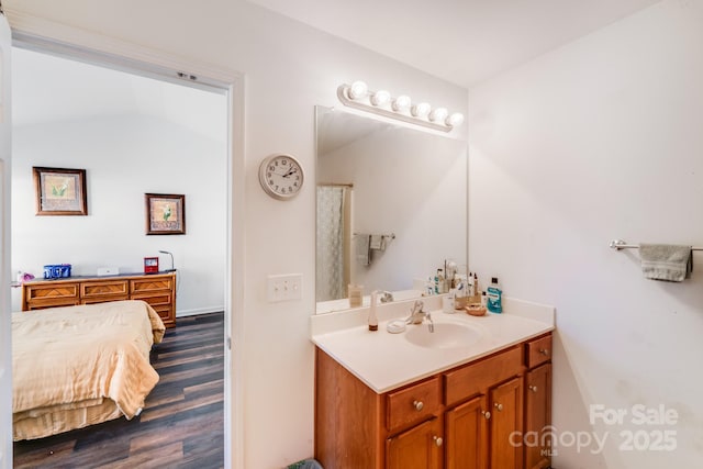 bathroom with ensuite bath, wood finished floors, and vanity