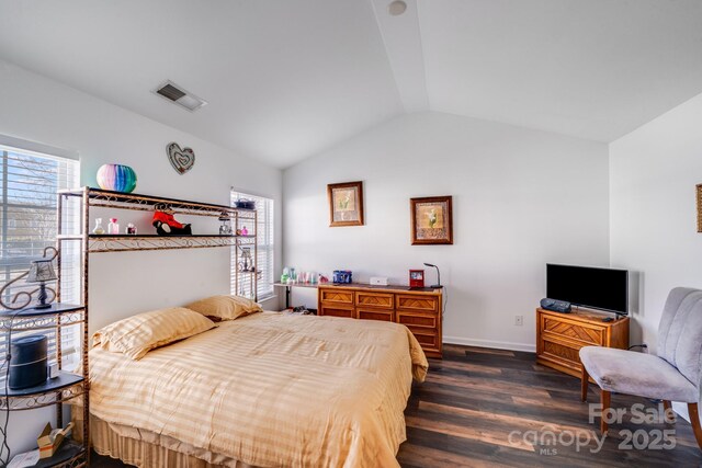 bedroom featuring dark wood-type flooring, visible vents, vaulted ceiling, and baseboards