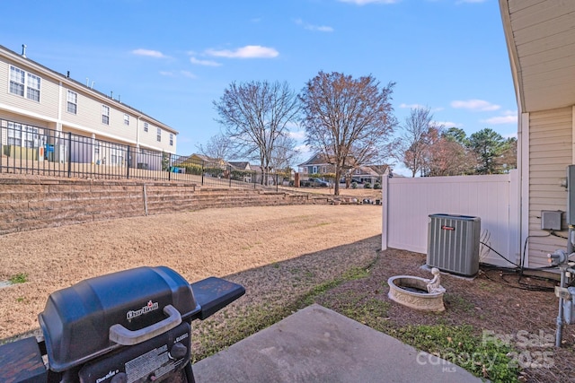 view of yard with a residential view, fence, and central air condition unit