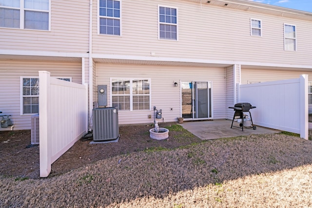 back of property featuring central air condition unit, fence, and a patio