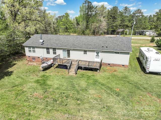 rear view of house featuring a wooden deck, a lawn, crawl space, and roof with shingles