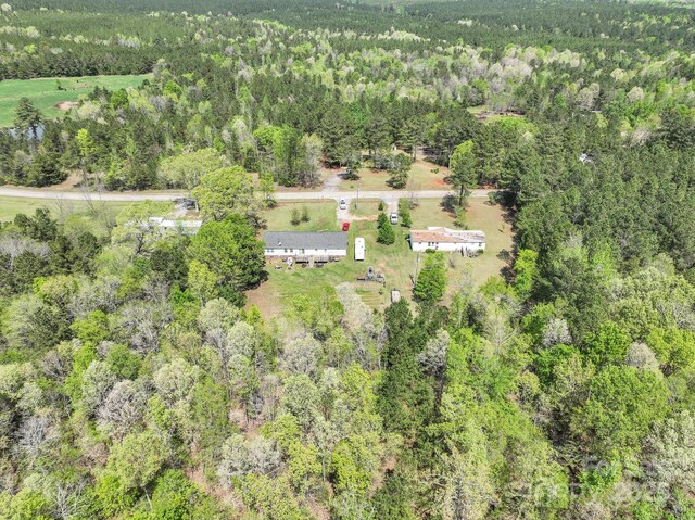bird's eye view with a wooded view