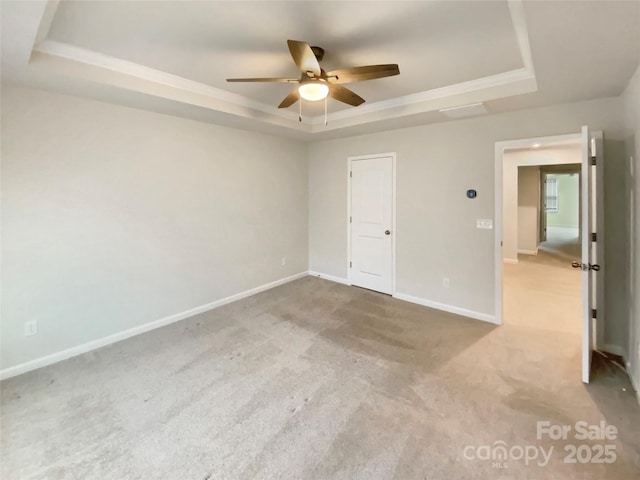 interior space with carpet flooring, ceiling fan, and a raised ceiling