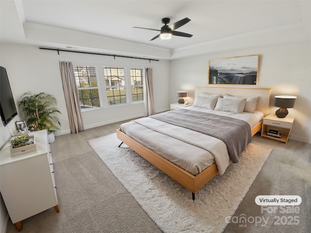 bedroom with a tray ceiling and ceiling fan