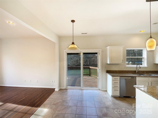 kitchen featuring white cabinetry, hanging light fixtures, sink, stainless steel dishwasher, and dark stone countertops