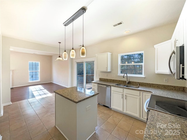 kitchen featuring sink, white cabinets, stainless steel appliances, and a center island